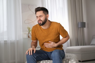 Young man suffering from stomach ache at home. Food poisoning