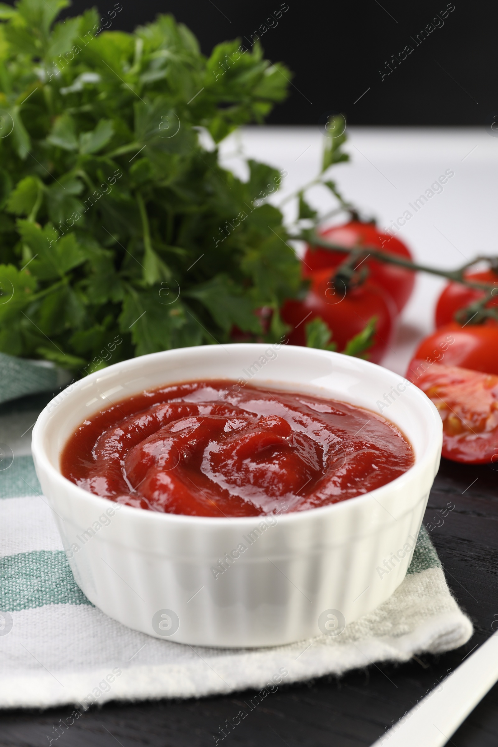 Photo of Organic ketchup in bowl on table, closeup. Tomato sauce