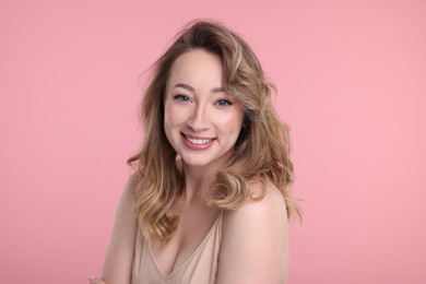 Photo of Portrait of smiling woman on pink background