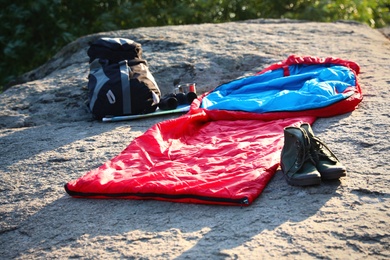 Sleeping bag and other camping gear outdoors on sunny day