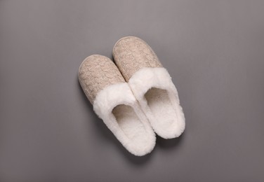 Pair of beautiful soft slippers on grey background, top view