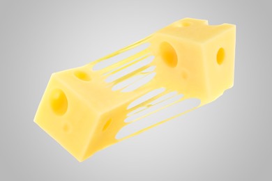 Image of Tasty cheese stretching in air on grey background