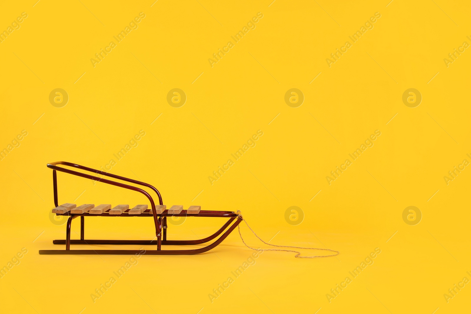 Photo of Stylish sleigh on yellow background, space for text