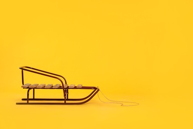 Stylish sleigh on yellow background, space for text