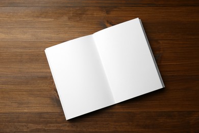 Open blank paper brochure on wooden table, top view. Mockup for design