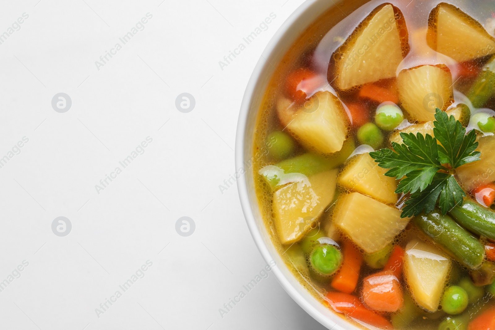 Photo of Bowl of delicious turnip soup on white table, top view. Space for text