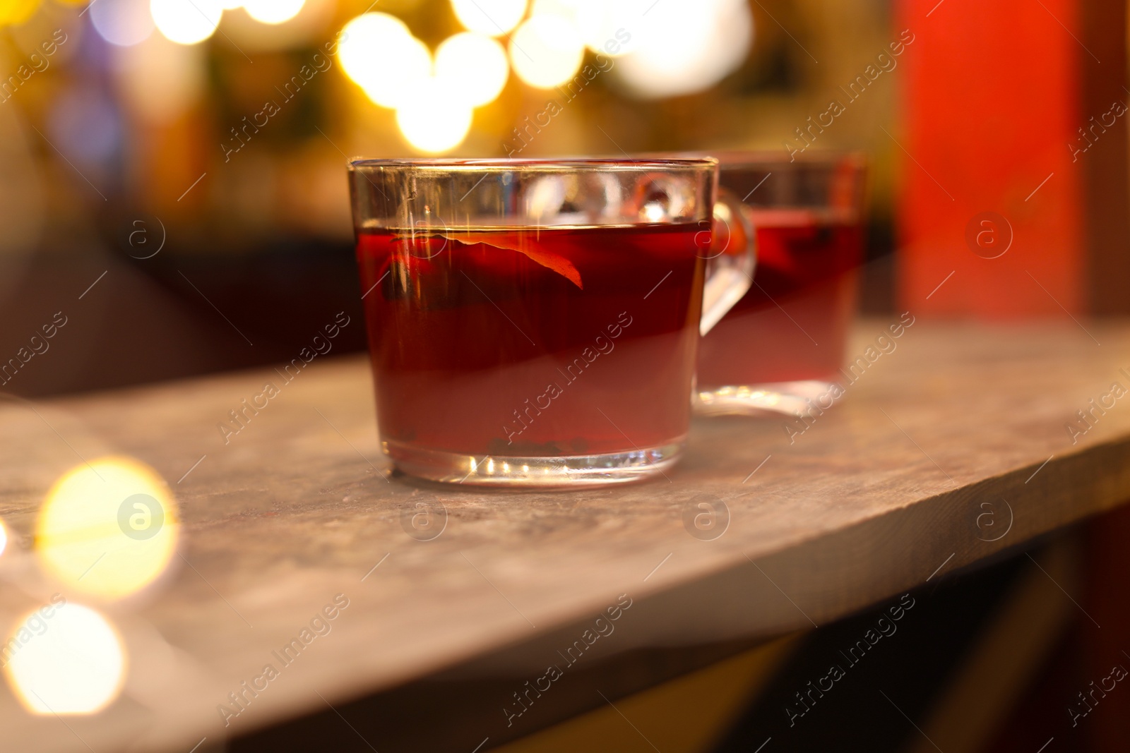 Photo of Tasty aromatic mulled wine on wooden table