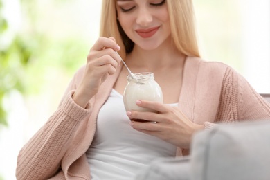 Young woman with yogurt indoors