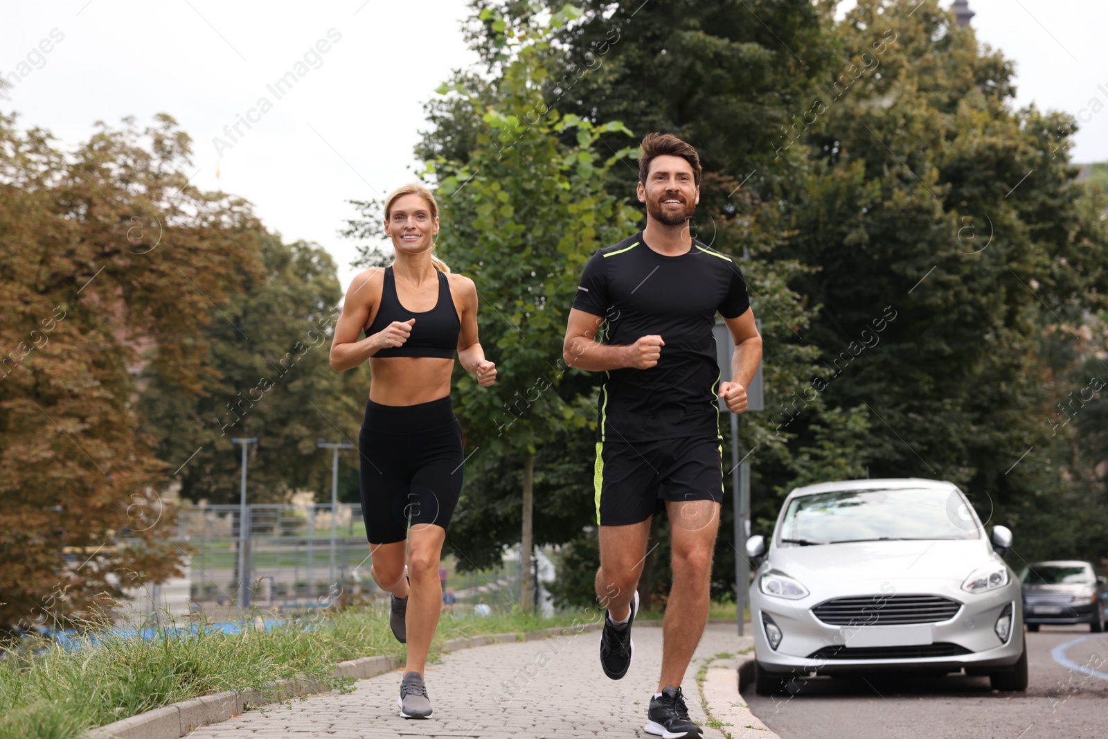 Photo of Healthy lifestyle. Happy sporty couple running outdoors