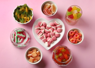 Photo of Flat lay composition with different jelly candies on pink background