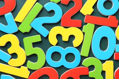 Photo of Colorful numbers on green background, top view