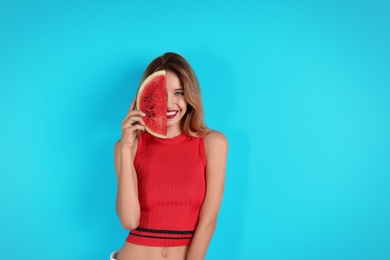 Pretty young woman with juicy watermelon on color background