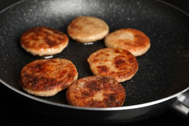 Cooking vegan cutlets in frying pan, closeup