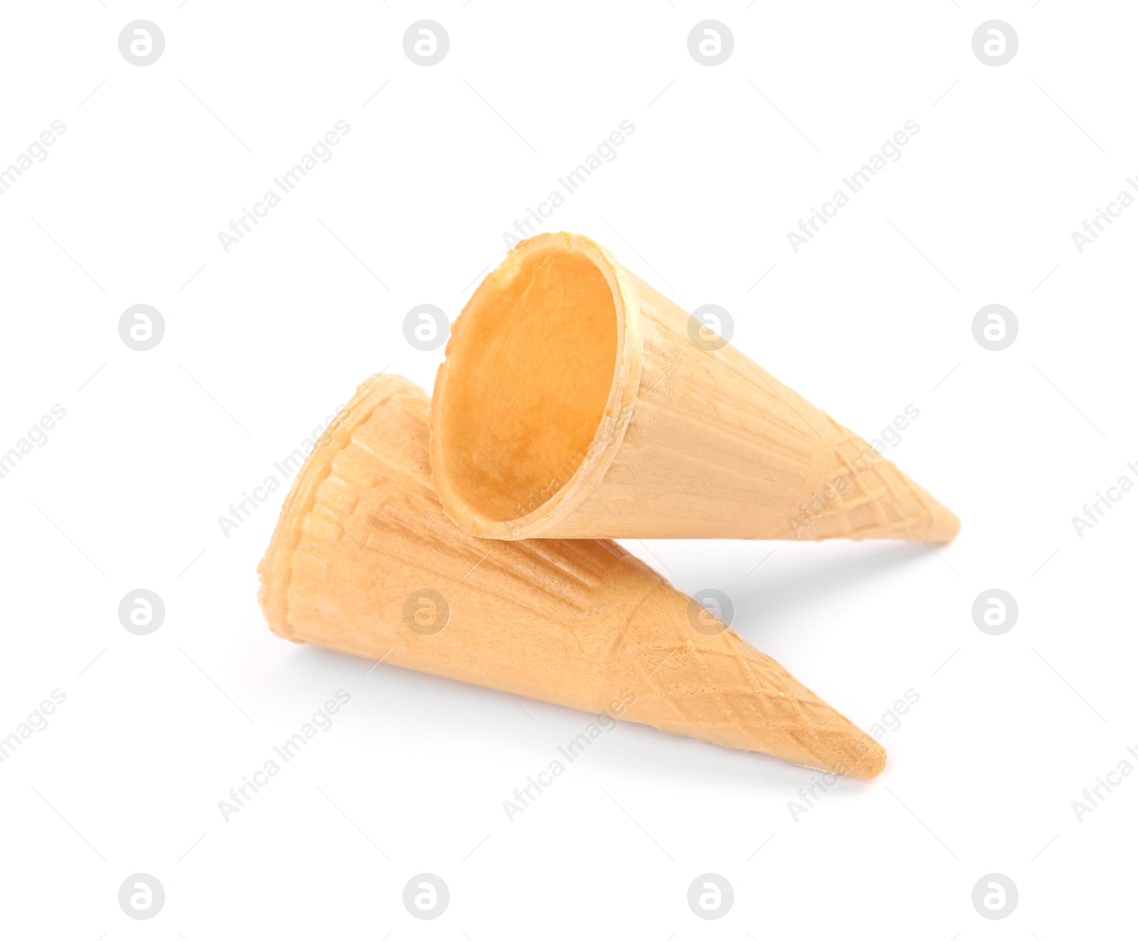 Photo of Empty crispy waffle cones for ice cream on white background