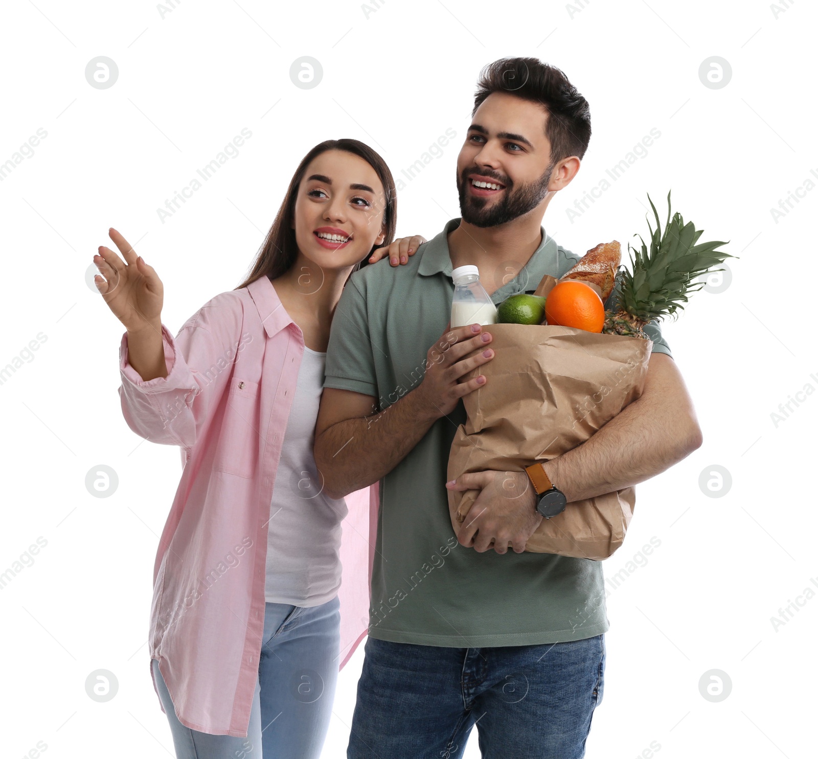 Photo of Young couple with groceries on white background