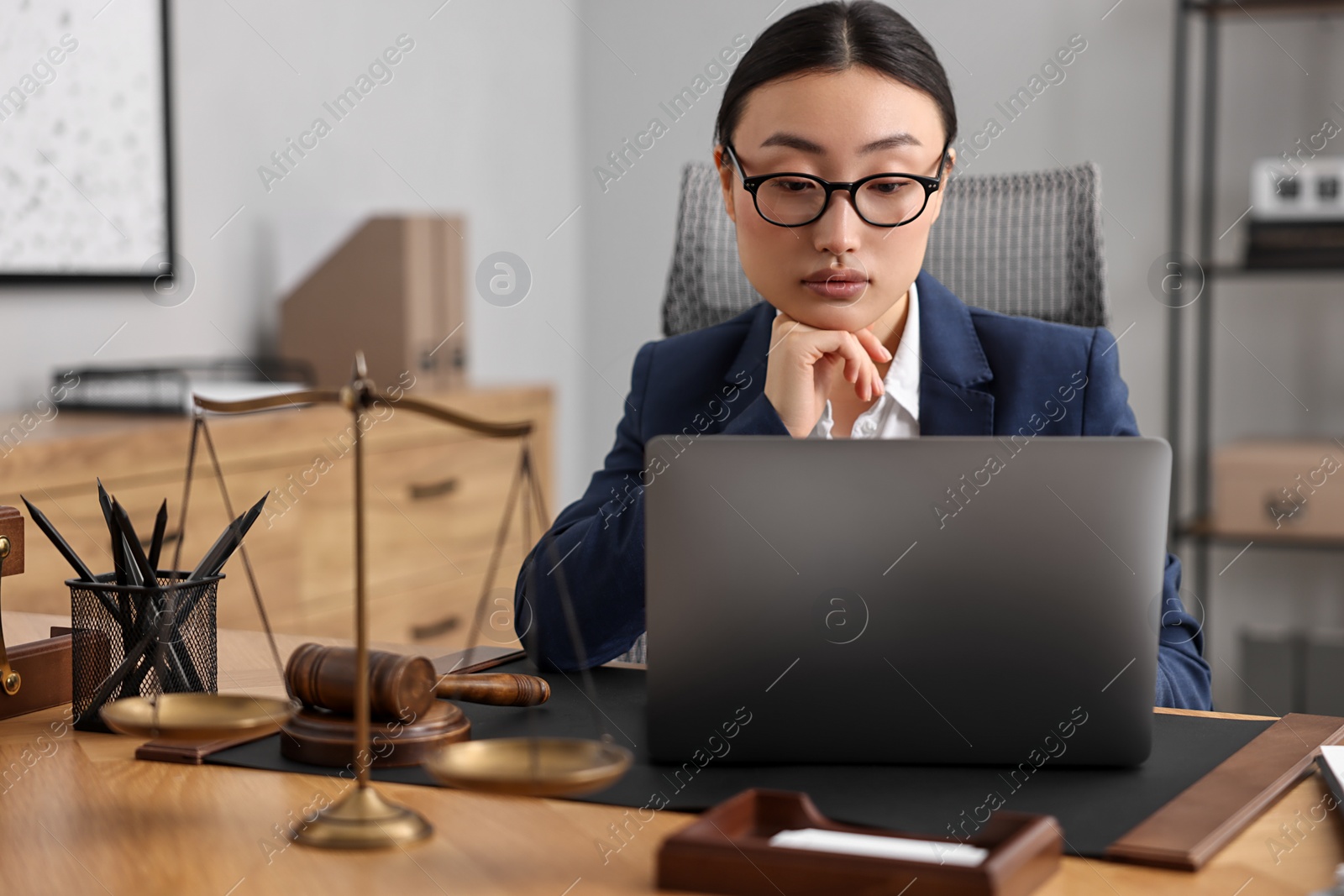 Photo of Notary working with laptop at table in office