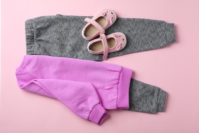 Flat lay composition with cute child clothes and shoes on color background