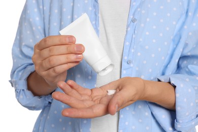 Woman applying cream on her hand against white background, closeup