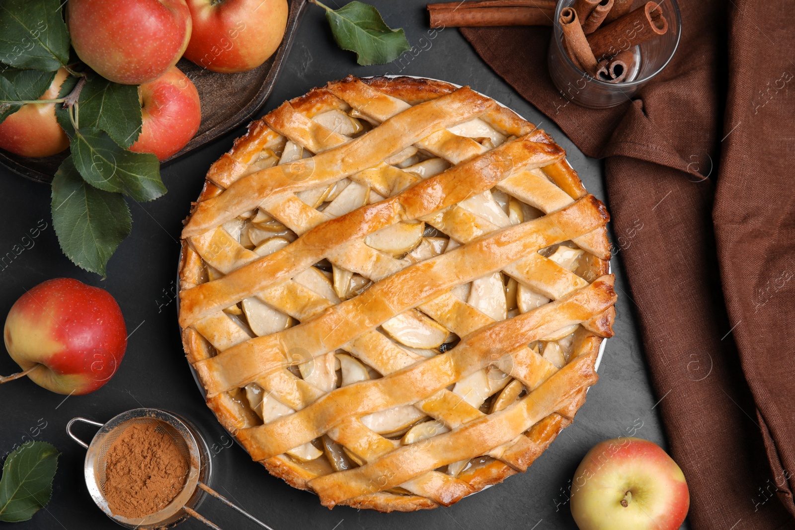Photo of Delicious traditional apple pie on black table, flat lay