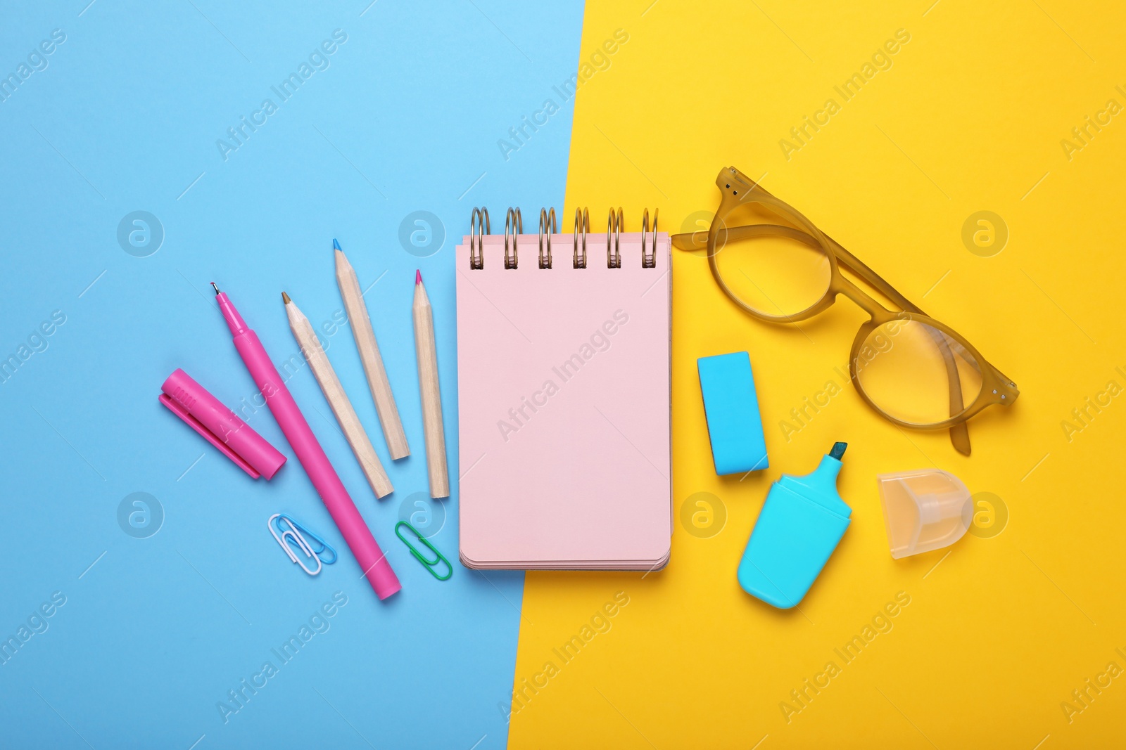 Photo of Flat lay composition with pink notebook and other school stationery on color background, space for text. Back to school