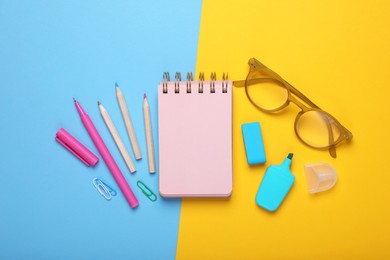 Flat lay composition with pink notebook and other school stationery on color background, space for text. Back to school