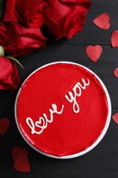 Photo of Bento cake with text Love You, roses and paper hearts on black wooden table, flat lay. St. Valentine's day surprise