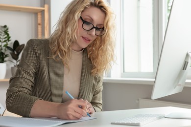 Photo of Beautiful young woman working with computer at desk in office
