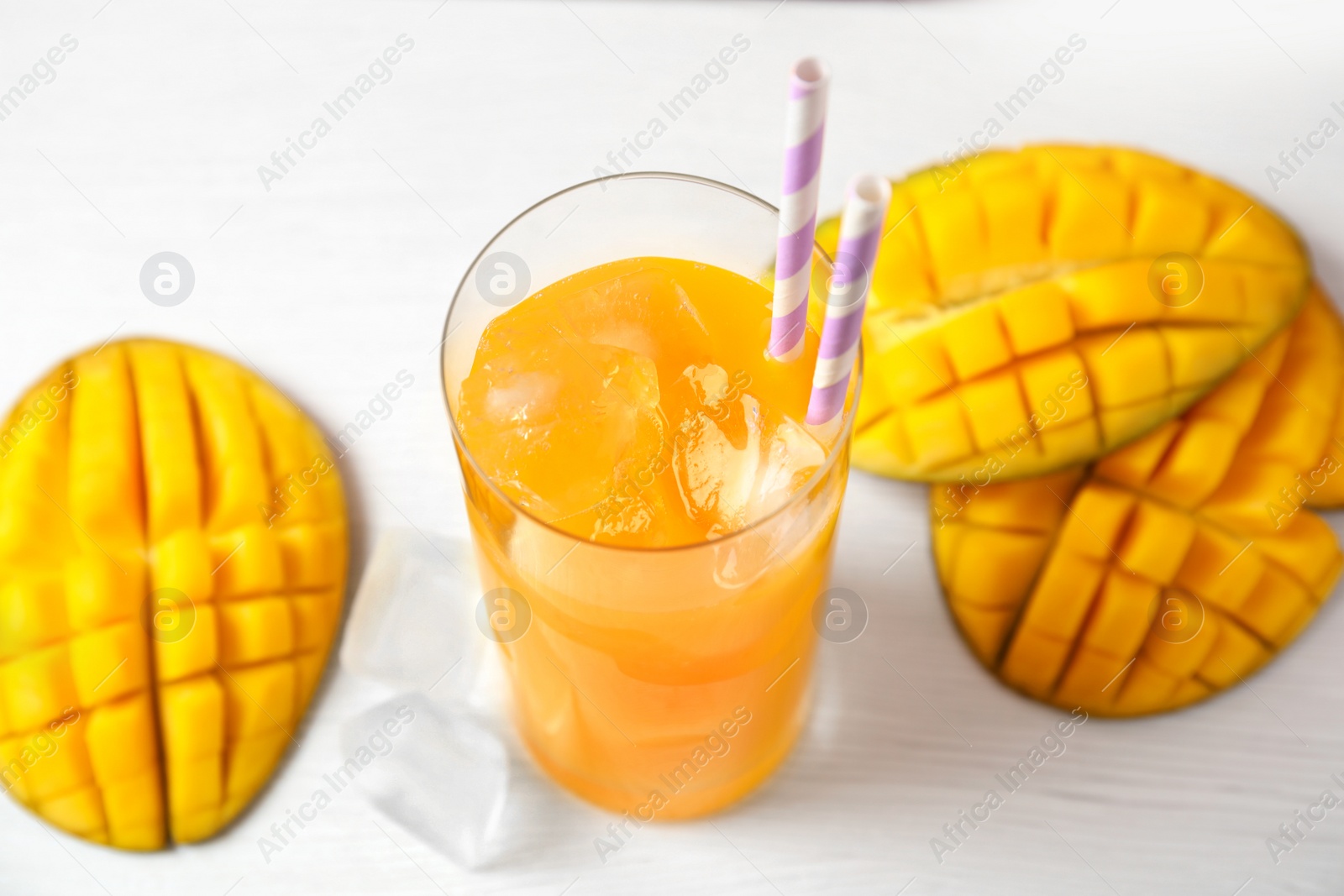 Photo of Fresh mango drink and fruits on table, closeup