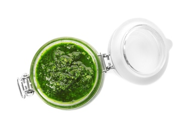 Photo of Homemade basil pesto sauce in glass jar on white background, top view