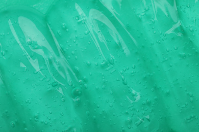 Photo of Pure transparent cosmetic gel on turquoise background, closeup