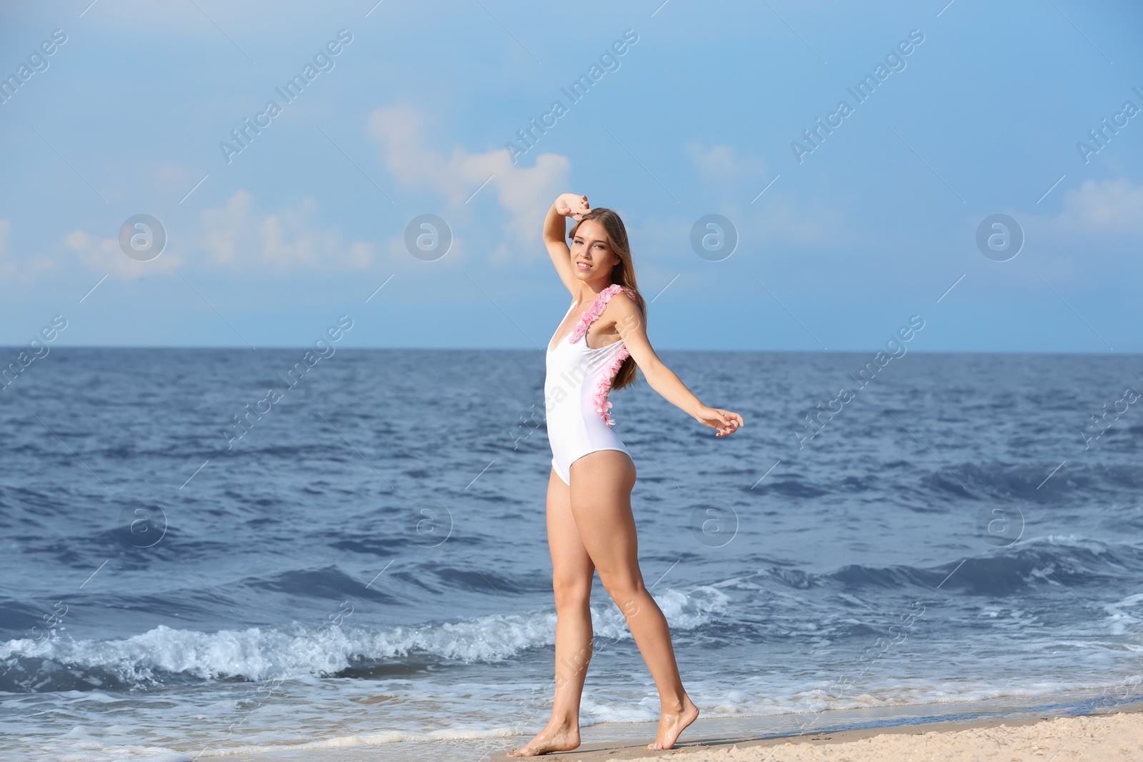 Photo of Attractive young woman in beautiful one-piece swimsuit on beach