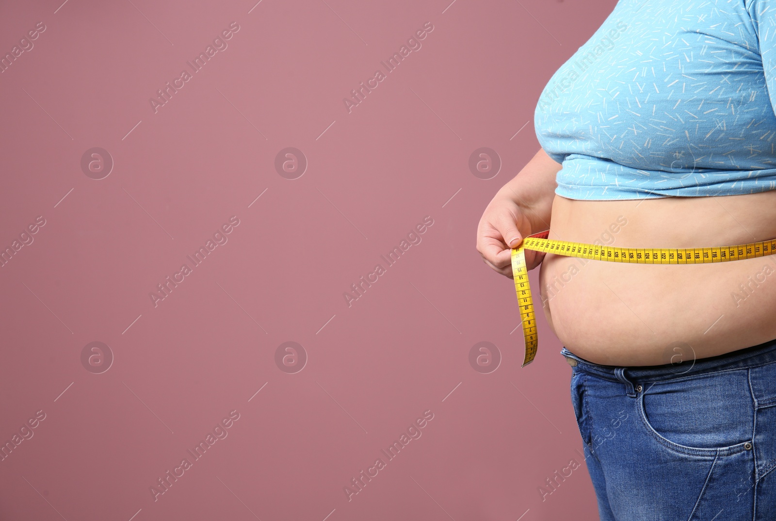 Photo of Overweight woman with measuring tape on color background