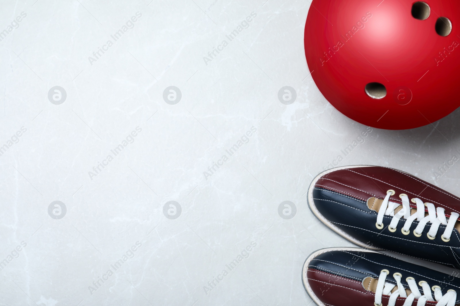Photo of Bowling ball and shoes on light grey marble background, flat lay. Space for text