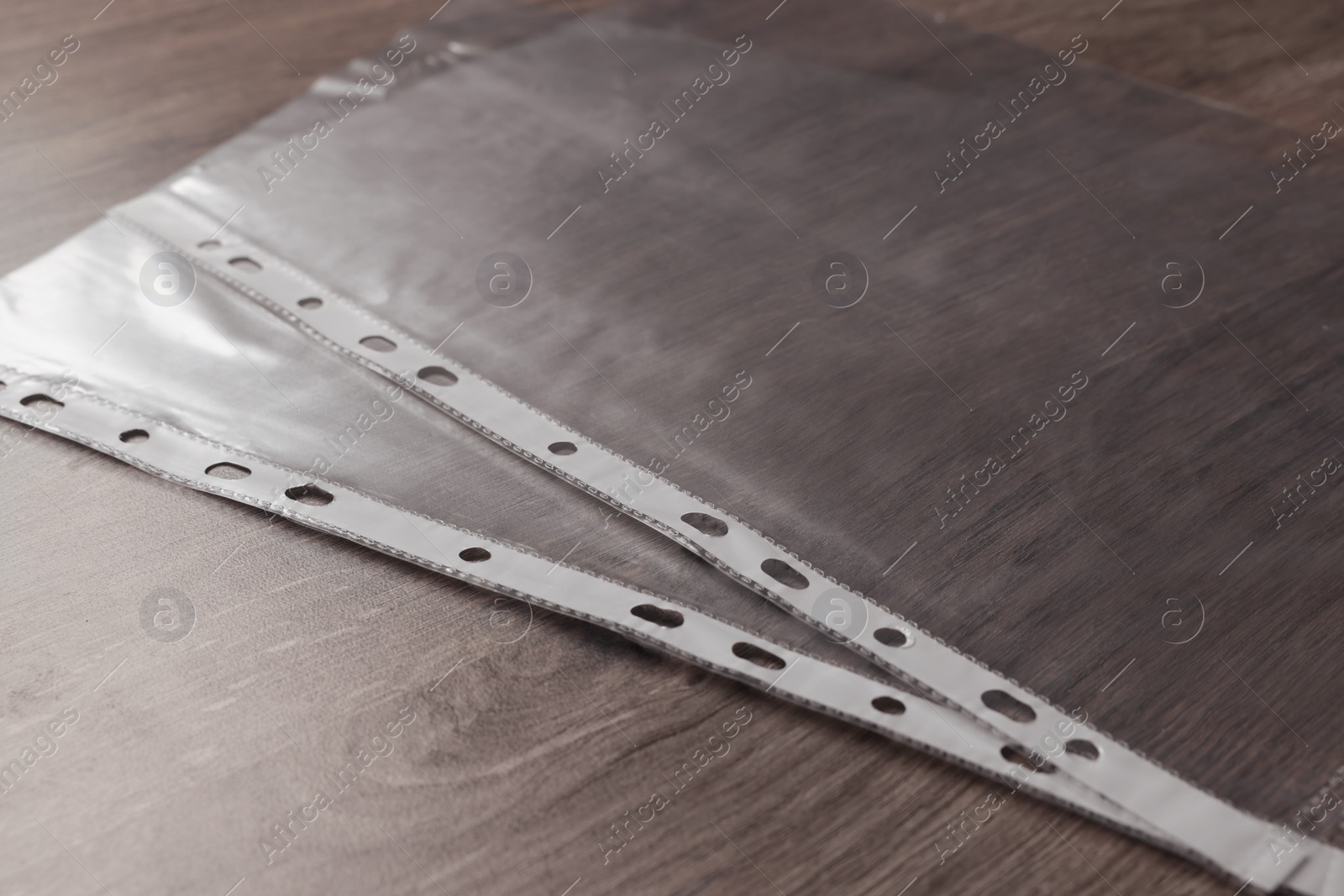 Photo of Punched pockets on wooden table, closeup view