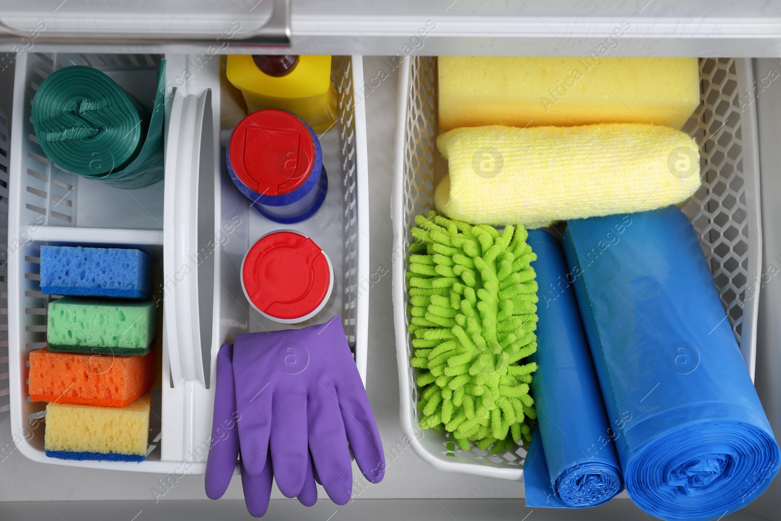 Photo of Different cleaning supplies in open drawer, top view