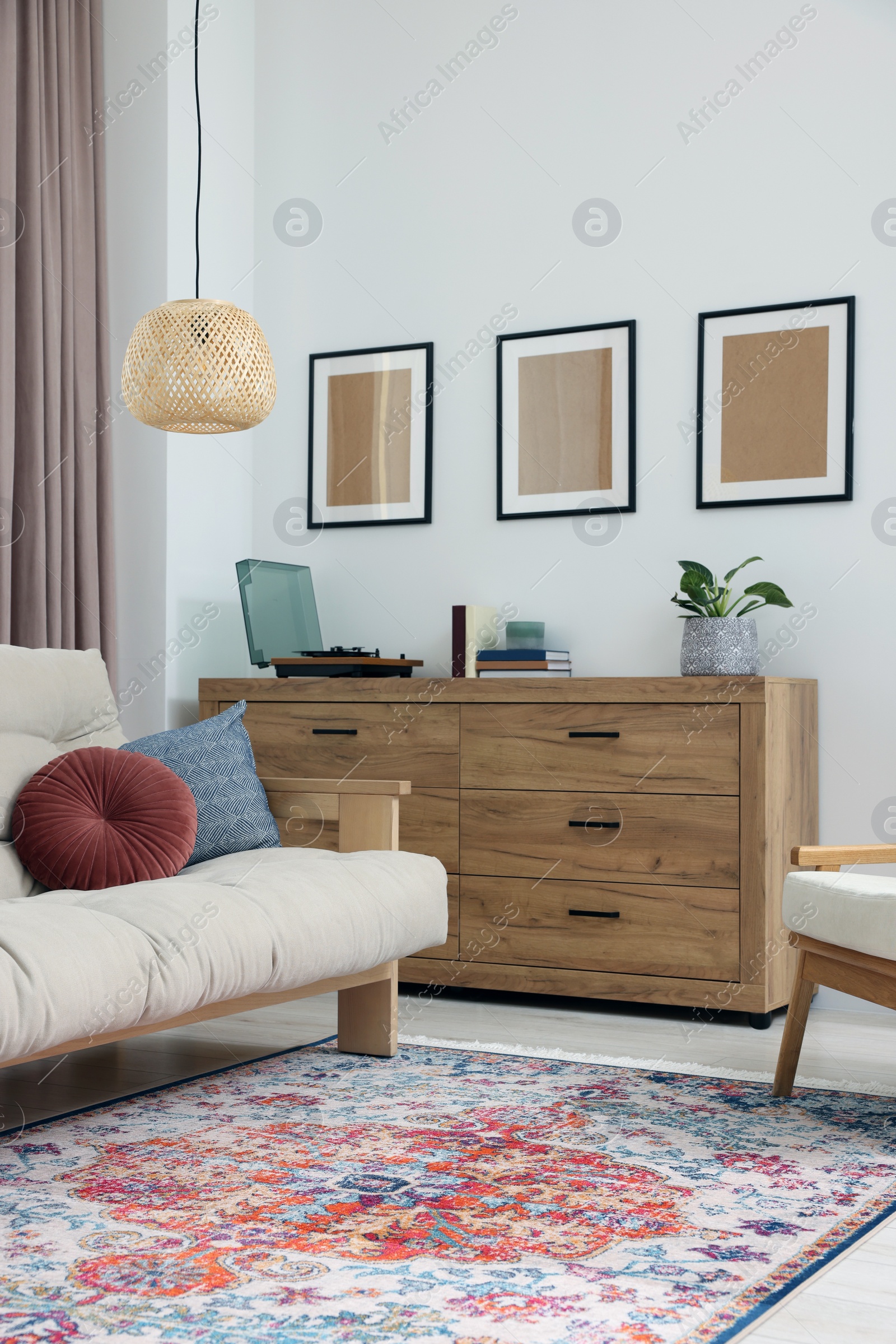 Photo of Beautiful rug, sofa and chest of drawers indoors