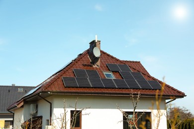 Photo of House with installed solar panels on roof. Alternative energy