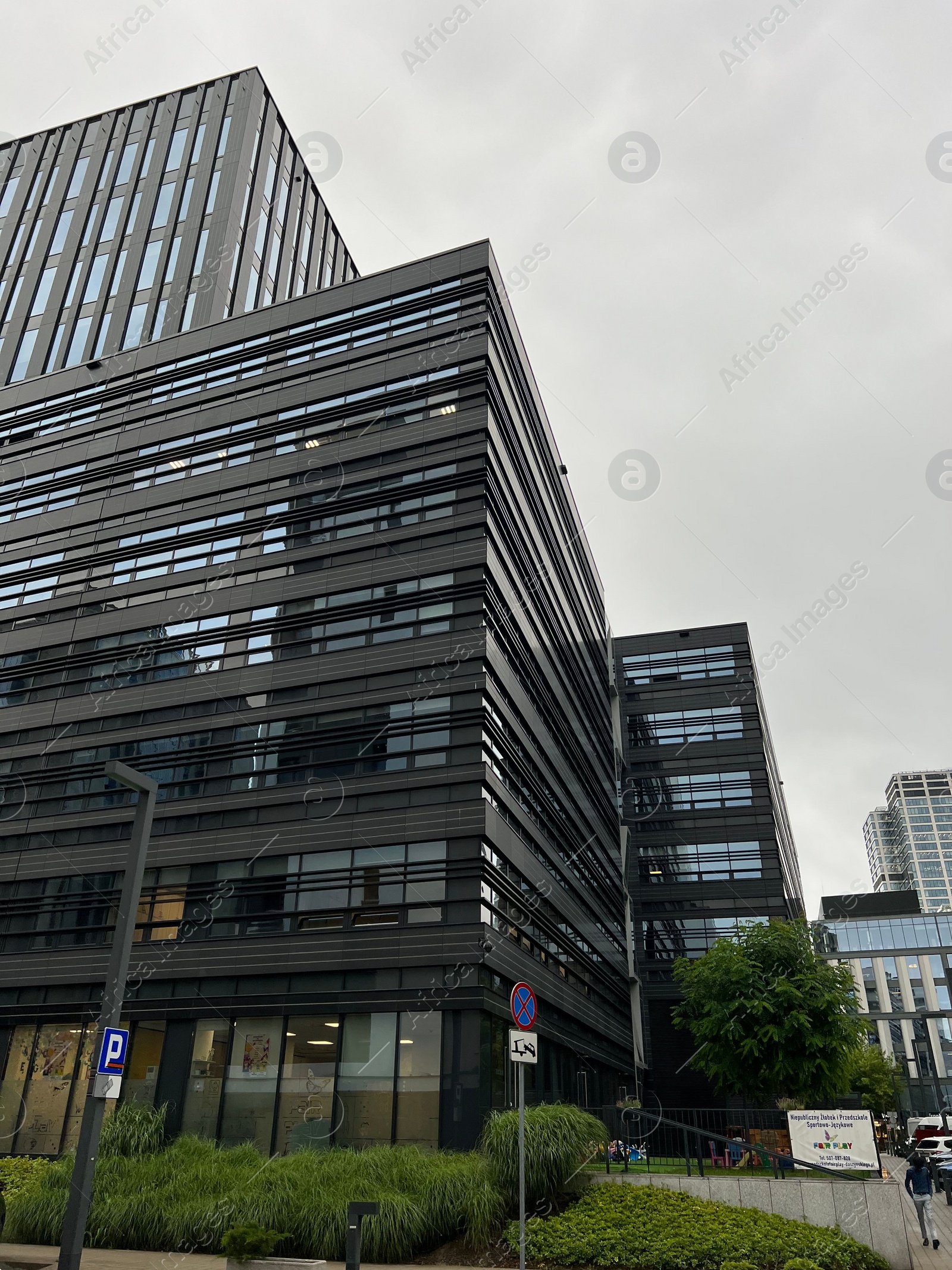 Photo of WARSAW, POLAND - JULY 11, 2022: Exterior of modern office building in city center, low angle view