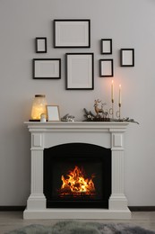 Photo of Stylish interior decorations on fireplace near white wall indoors