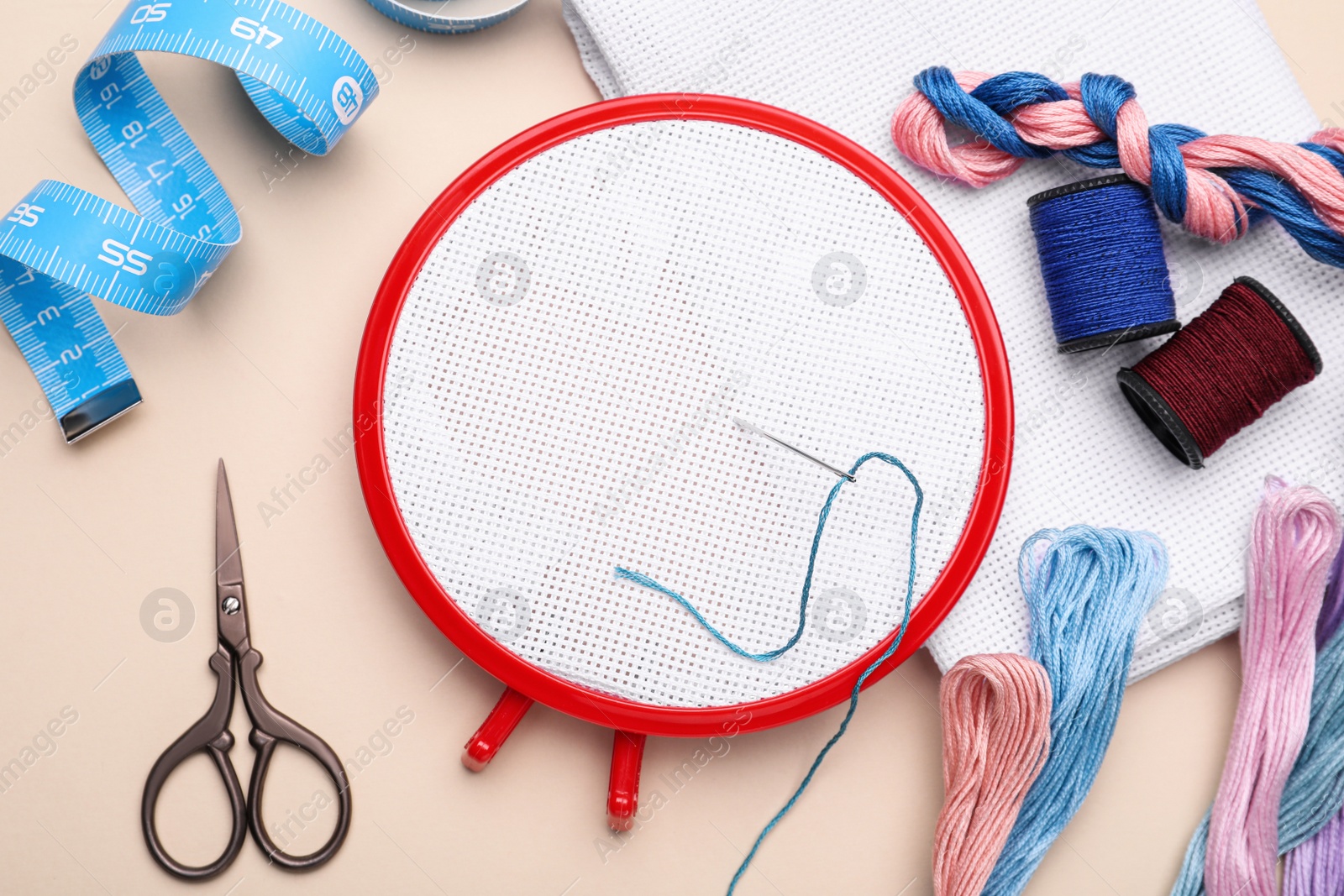 Photo of Flat lay composition with embroidery hoop on beige background