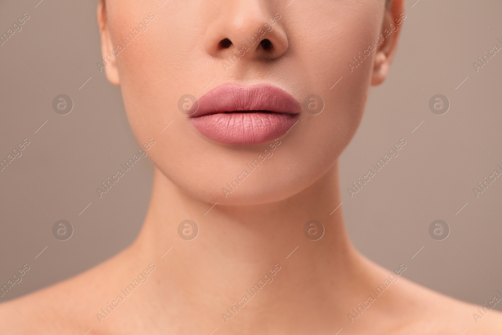 Photo of Woman with pink lipstick on brown background, closeup