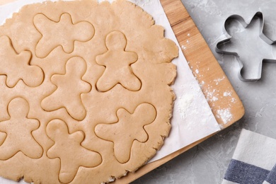 Photo of Making homemade Christmas cookies on light grey marble table, flat lay. Gingerbread men