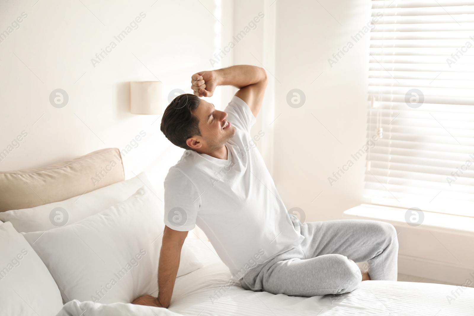 Photo of Man awakening on bed at home. Lazy morning