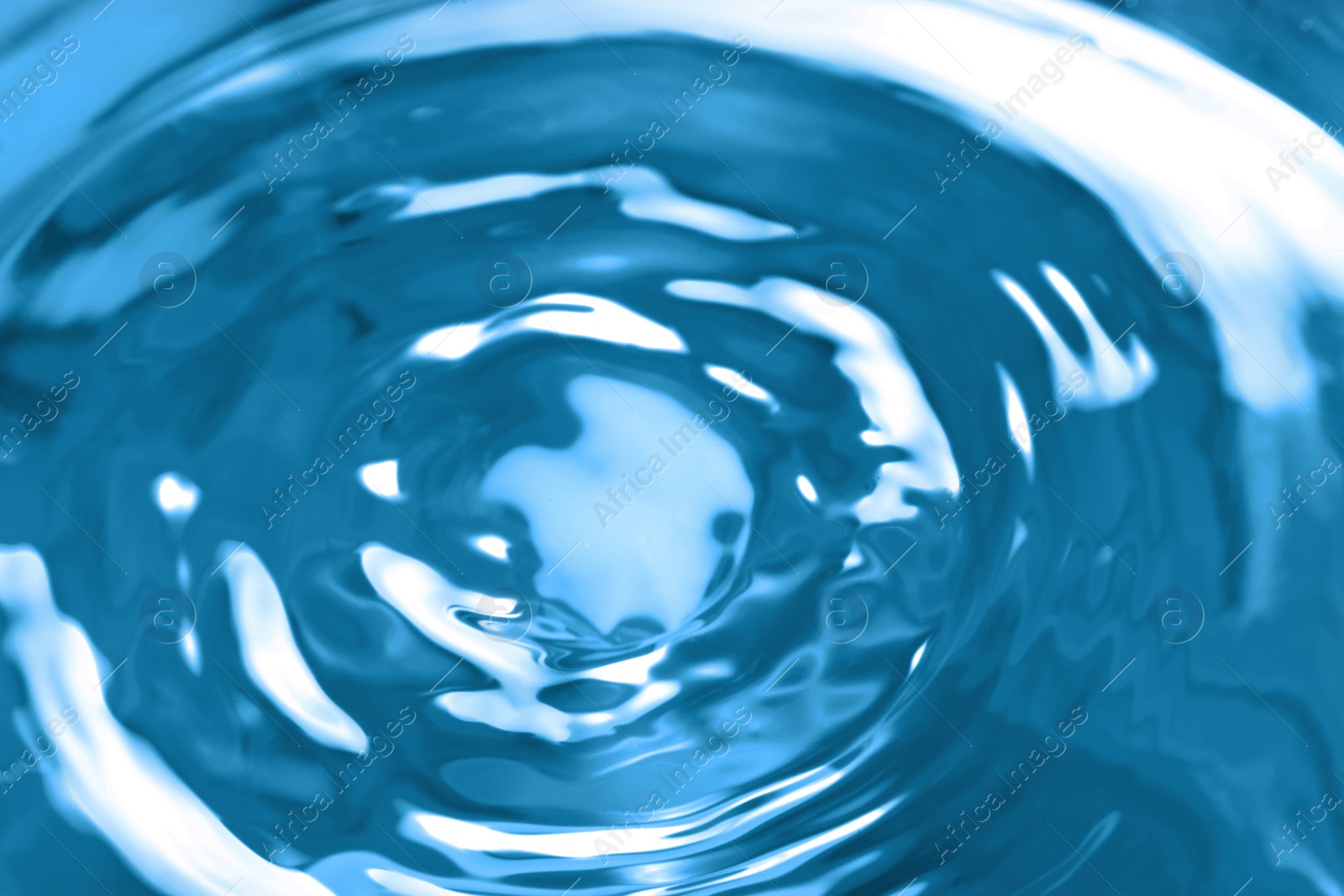 Photo of Splash of clear water on blue background, closeup