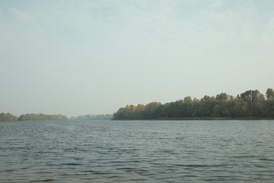 Photo of Beautiful lake and shore with trees under sky