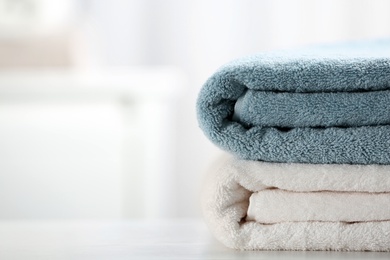 Stack of fresh towels on table, closeup. Space for text