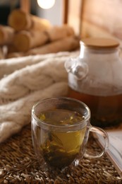 Photo of Freshly brewed tea on wicker table in room. Cozy home atmosphere