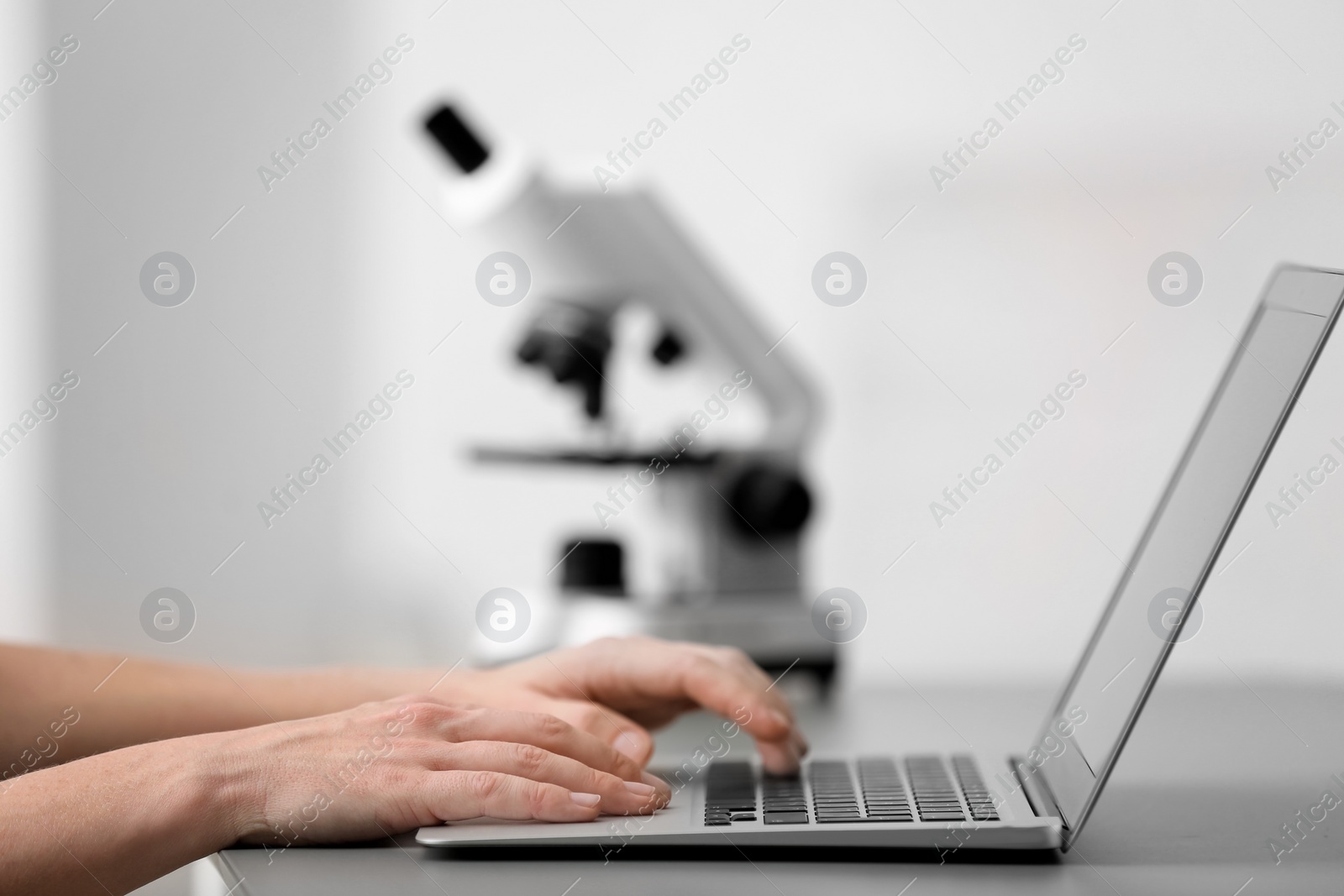 Photo of Female student working with laptop at table. Medical education