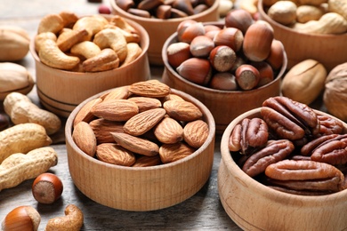 Bowls with organic nuts on wooden table. Snack mix