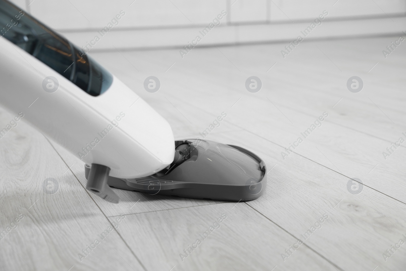 Photo of Cleaning floor with steam mop at home, closeup. Space for text